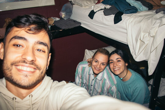 Friends taking selfies in a hostel room