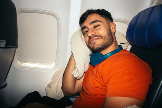 Flash-lit traveler smiling on plane