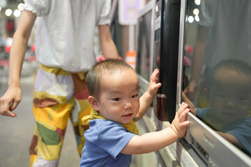In an old-town-style mall, a Chinese family enjoys the day; a one-year-old in a stroller and kids...