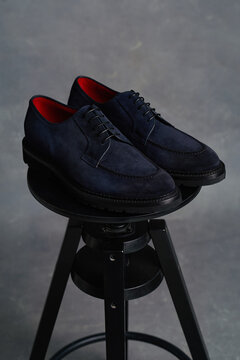 Stylish dark navy shoes on black stool with red interior