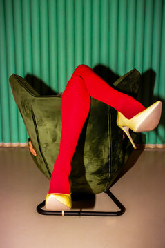 Legs in Bright Tights Hanging Over Back of Armchair
