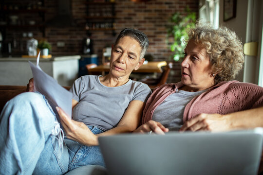 Lesbian couple reviewing financial documents together at home