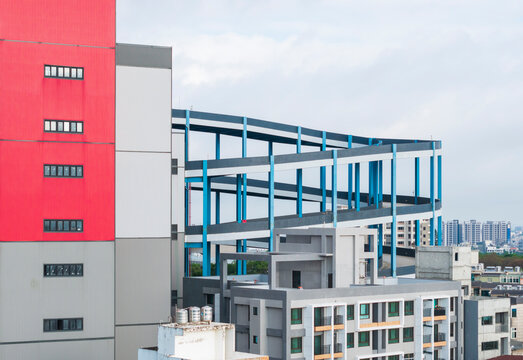 Industrial Building With Blue Spiral Structure And City Backgrou