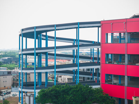 Industrial Building With Blue Spiral Structure And City Backgrou