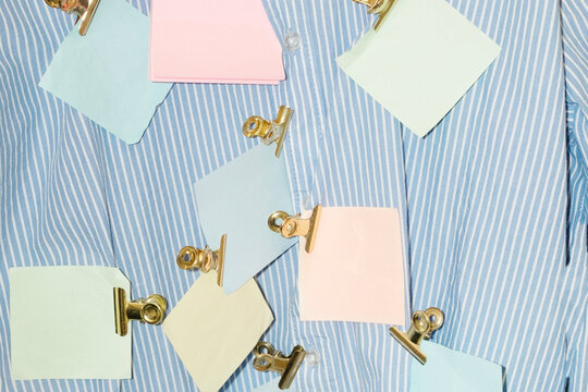 Striped formal office shirt with post it notes in it with golden clip