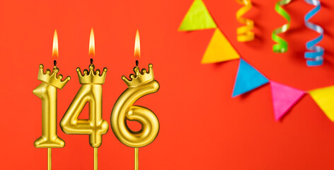 Number 146 birthday candle on an orange background with pennants