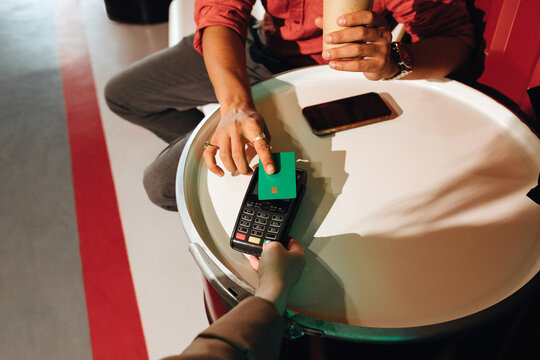 Anonymous man's hand paying with a  credit card via a pos terminal.