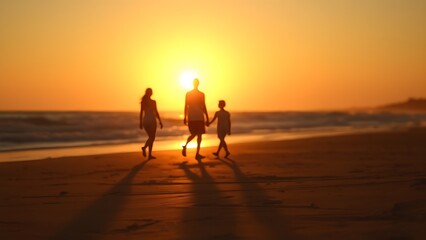 Fototapeta premium Sunset at the beach with golden light and distant silhouettes of a family.