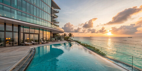 Luxurious beachfront hotel with infinity pool overlooking turquoise ocean, modern glass architecture, sunrise view, ultra-realistic style.

