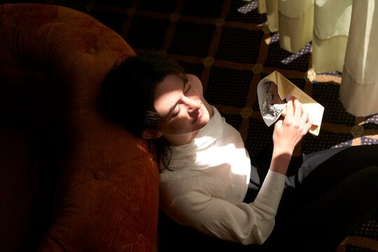 Woman Enjoys Quiet Moment With Chocolate in Sunlit Room