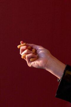 Hand Holding Crispy Snacks Against a Vibrant Background
