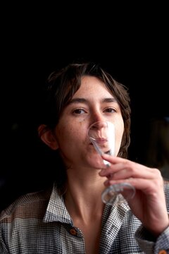 Young Woman Enjoys a Drink in a Cozy Indoor Setting