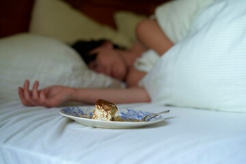 Delicious dessert on a plate next to a person sleeping peacefully
