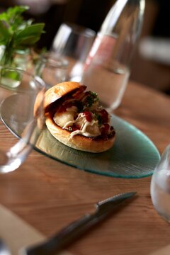 Unique sandwich served on a glass plate in a cozy dining setting