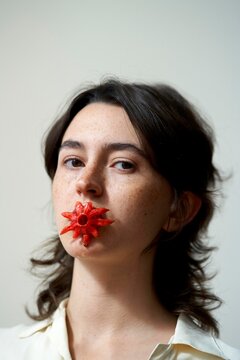 Unique Art Expression With a Red Flower in the Mouth of a Woman