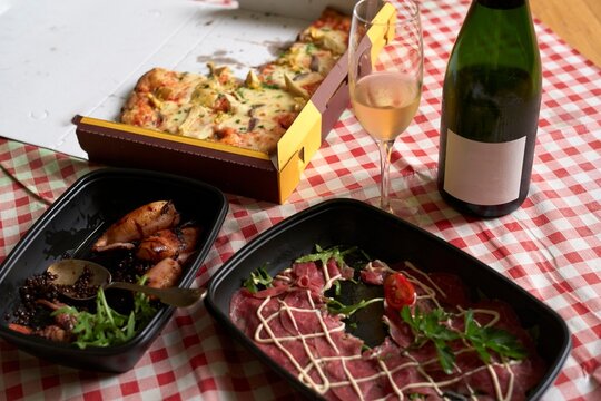 Meal spread with pizza, carpaccio, calamari and sparkling wine