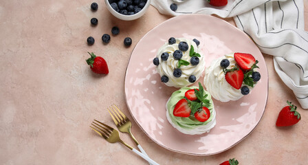 Sweet Pavlova cakes with fresh berries on beige background, top view
