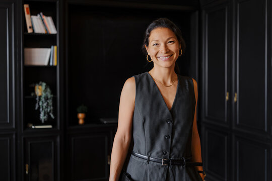 Lawyer smiling in her office with bookshelves in background