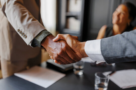Business people shaking hands after closing a deal in lawyers office