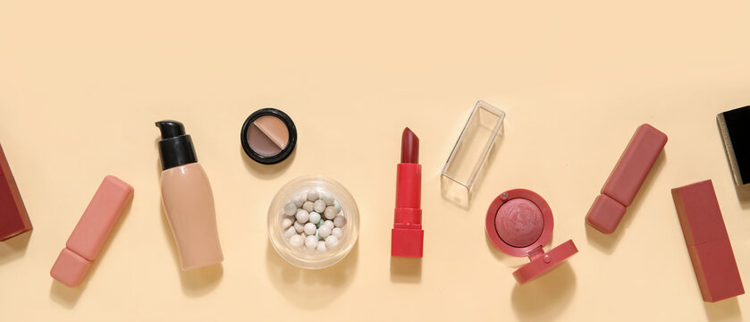 Decorative cosmetics with lipsticks on beige background