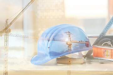 Double exposure of hardhat with tools and construction site