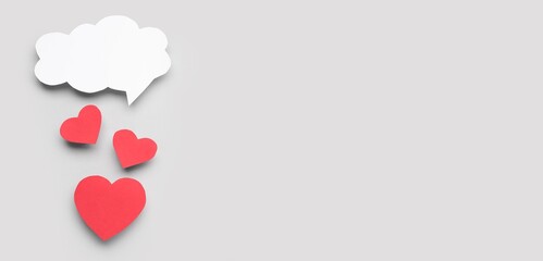 Paper hearts and blank speech bubble on grey background with space for text. Dialogue concept