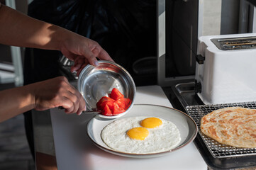 Chef serves fried eggs in a cafe. 