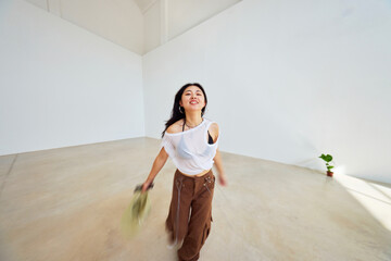 Dancer expresses joy in spacious studio during bright afternoon