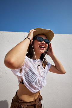 Smiling woman enjoying sunny day outdoors with stylish summer ou