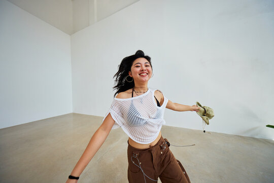 Woman joyfully dancing in an empty studio space