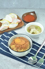 Steamed rice with chicken and egg, served with cracker and chilli,  comfort food for breakfast