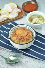 Steamed rice with chicken and egg, served with cracker and chilli,  comfort food for breakfast