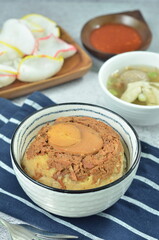 Steamed rice with chicken and egg, served with cracker and chilli,  comfort food for breakfast