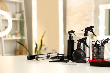 Hair sprays with extension tools on table in beauty salon, closeup