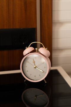 Pink Alarm Clock on a Nightstand
