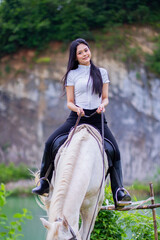 Cute Young Woman Riding White Horse in Outdoor Equestrian Setting
