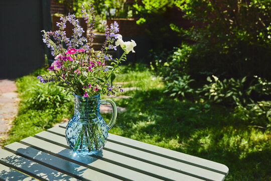 Blue glass pitcher with garden flowers