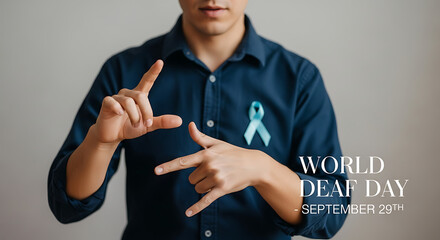 A person signing with hands wearing a blue shirt and a ribbon for world deaf day september twenty ninth