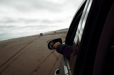 Driving Along a Sandy Beach With a Carefree Vibe and Cloudy Skies