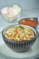 Rice porridge served with shredded with shredded Cchicken, cakwe, crackers, and chilli