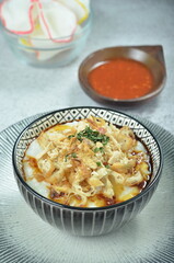 Rice porridge served with shredded with shredded Cchicken, cakwe, crackers, and chilli