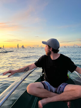 Man sitting on boat during sunset sail