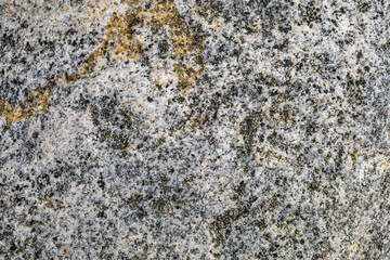 Texture of stone surface with white, black and yellow inclusions
