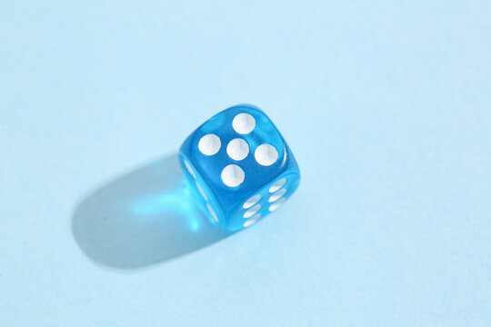Blue game dice on color background