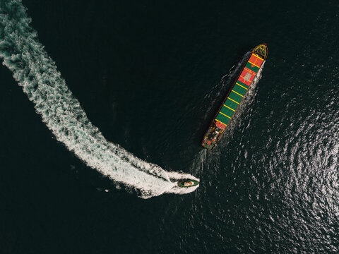 Cargo ship and escort pilot boat in motion
