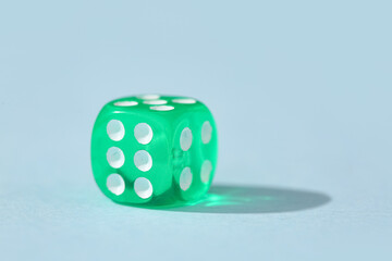 Green game dice on blue background