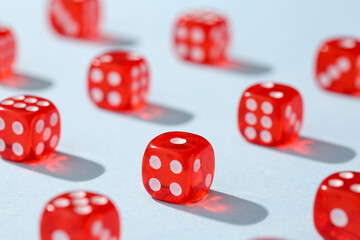 Many red game dices on blue background, closeup