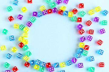 Frame made of colorful game dices on blue background