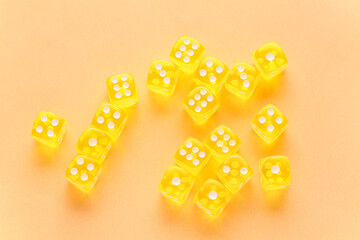 Many yellow game dices on orange background