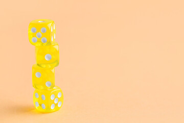 Stack of yellow game dices on orange background